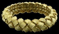 An 18ct gold bracelet by Kutchinsky, the articulated domed design composed of overlapping textured leaves, the clasp...