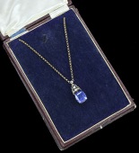 An Art Deco Sri Lankan sapphire and diamond pendant on chain, the cushion-cut sapphire claw set beneath an...