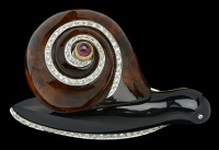 An amber, onyx and diamond novelty snail brooch, the high domed amber shell with spiral of brilliant-cut diamonds,...