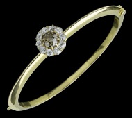 A late 19th century gold mounted diamond cluster set bangle, adapting to a bar brooch, the bangle centred with an...