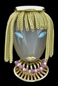 A 1950s gem set novelty brooch, by André Col, modelled as a stylized female mask, the angular face of polished...