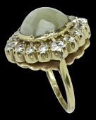 A late Victorian chrysoberyl and diamond cluster ring, the high domed cabochon collet set within a surround of claw...