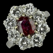 A ruby and diamond cluster ring, the oval mixed-cut ruby claw set within a surround of eight brilliant-cut diamonds,...