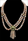 A festoon necklace, composed of coral coloured beads, the central inverted yellow precious metal spade-shaped panel...