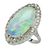 An opal and diamond cluster ring, the oval cabochon white opal claw set within an Edwardian style navette-shaped...