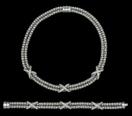 A diamond set necklace and bracelet suite, each composed of two uniform snake-link chains, joined at intervals by...