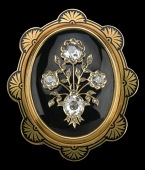 A late Victorian diamond set mourning brooch/pendant, the domed oval onyx panel supporting a floral spray motif set...