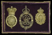 State Harness Badges of George III, Queen Adelaide, and the Prince Regent.
A glazed and framed collection of three...
