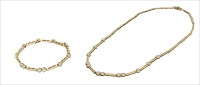 A diamond necklace and bracelet suite, designed as a series of reeded batons interspersed with brilliant-cut...
