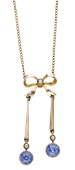 An early 20th century sapphire bow pendant, the stylised bow surmount suspending two knifewire drops each terminating...
