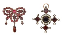 Two early 19th century garnet jewels, the first of stylised bow design suspending three drops, set throughout with...