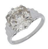 A diamond single stone ring, the old cushion-cut diamond of light brown tint, weighing 4.67 carats, between stepped...
