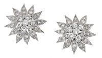 A pair of diamond earrings by Andrew Grima, 1983, the stylised flowerheads set throughout with brilliant and...
