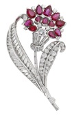 A ruby and diamond spray brooch, circa 1950, the baguette-cut diamond stem issuing a bouquet of pear-shaped rubies...
