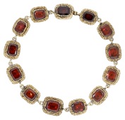 A garnet bracelet, circa 1830, set with cushion-shaped garnets in scroll and foliate closed-back settings, mounted...