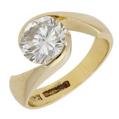 A diamond single stone ring, the brilliant-cut diamond between crossover shoulders, mounted in 18ct gold, UK...