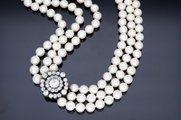 A cultured pearl necklace with a late 19th century diamond clasp, the three rows of cultured pearls to a detachable...