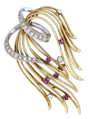 A ruby and diamond brooch, 1960, the stylised spray of openwork design, set with circular-cut rubies and...