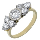 A diamond ring, 1995, set with a brilliant-cut diamond between trios of similarly-cut diamonds, mounted in 18ct...