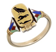 An Egyptian revival enamelled ring, circa 1870, the central cartouche bearing the hieroglyphs of owl, lion and...