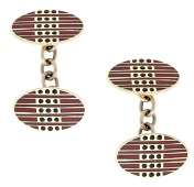 A pair of enamel cufflinks, French, the oval panels decorated with a geometric pattern in red and black enamel,...