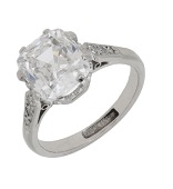 A diamond single stone ring, the cushion-shaped diamond, weighing 2.98 carats, between tapered shoulders set with...