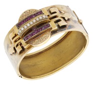 A mid 19th century gold bangle, the two demi-lune motifs engraved with foliate decoration, spaced by a series of...