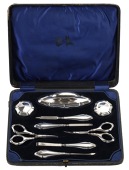 A silver mounted manicure set, comprising nine pieces, to include a pair of cosmetic pots and covers and a nail...