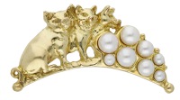 A ‘Pearls Before Swine’ brooch by Sarah Jones, 1994, the arc-shaped brooch modelled as three pigs seated before...