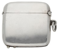 A silver vesta case, of plain rectangular form with rounded corners, incorporating a cigar cutter below, by...