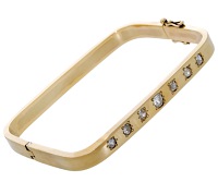 A diamond bangle, of flattened rectangular form, inlaid to the front with a graduated row of old cushion-shaped...