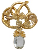A mid 19th century aquamarine brooch, the openwork knot with wraparound tendrils and leaves, suspending an oval-cut...