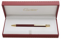 A ‘Must II’ ball point pen by Cartier, in red lacquer, signed ‘Must de Cartier’, numbered ‘603730’,...