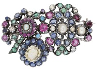 A gem-set brooch, the stylised bouquet set throughout with vari-cut emeralds, sapphires, pink sapphires, yellow...