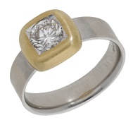 A diamond single stone ring, the bicoloured ring set with a brilliant-cut diamond  within a cushion-shaped mount, to...