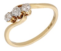 An early 20th century diamond ring, set with three old brilliant-cut diamonds between crossover shoulders, mounted...