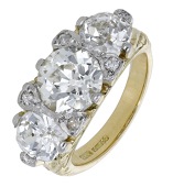 A diamond three stone ring, set with an old brilliant-cut diamond, weighing 2.23 carats, with a similarly-cut...