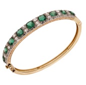 A late 19th century gem-set bangle, set to the front with cushion-shaped green  doublets and old brilliant-cut...