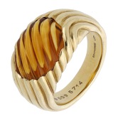 A citrine ring by Boucheron, the reeded citrine cabochon in a tapering bombé mount of similar design, signed,...