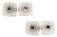 A pair of French chalcedony and sapphire cufflinks, the square domed chalcedony terminals each centred with a...
