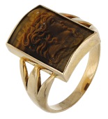 A hardstone cameo ring, the curved tiger’s-eye cameo carved to depict a classical female profile, ring size P. 	...