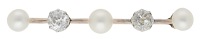 A pearl and diamond bar brooch, circa 1910, the knifewire bar set with three pearls and two old brilliant-cut...