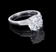 A diamond single stone ring, the brilliant-cut diamond, weighing 3.02 carats, between shoulders each set with a...