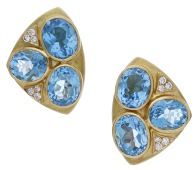 A pair of blue topaz and diamond ear clips, the triangular panels with a hammered finish and set with three oval-cut...