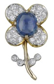 A sapphire and diamond brooch, designed as a flower with a central sapphire cabochon, the petals and leaves set with...