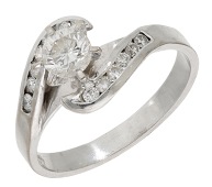 A diamond ring, the brilliant-cut diamond claw-set between crossover shoulders channel-set with similarly-cut...