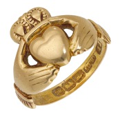 A late 19th century Irish gold Claddagh ring, the bezel modelled as hands clasping a crowned heart, the band...