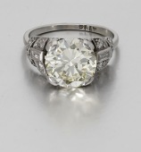 An Art Deco diamond ring, the transitional-cut diamond, weighing 3.92 carats, between demi-lune shoulders set with...