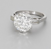 A diamond single stone ring, set with a brilliant-cut diamond, weighing 5.00 carats, between shoulders each set with...