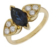 A sapphire and diamond ring, the marquise-shaped sapphire between trios of brilliant-cut diamonds, total diamond...